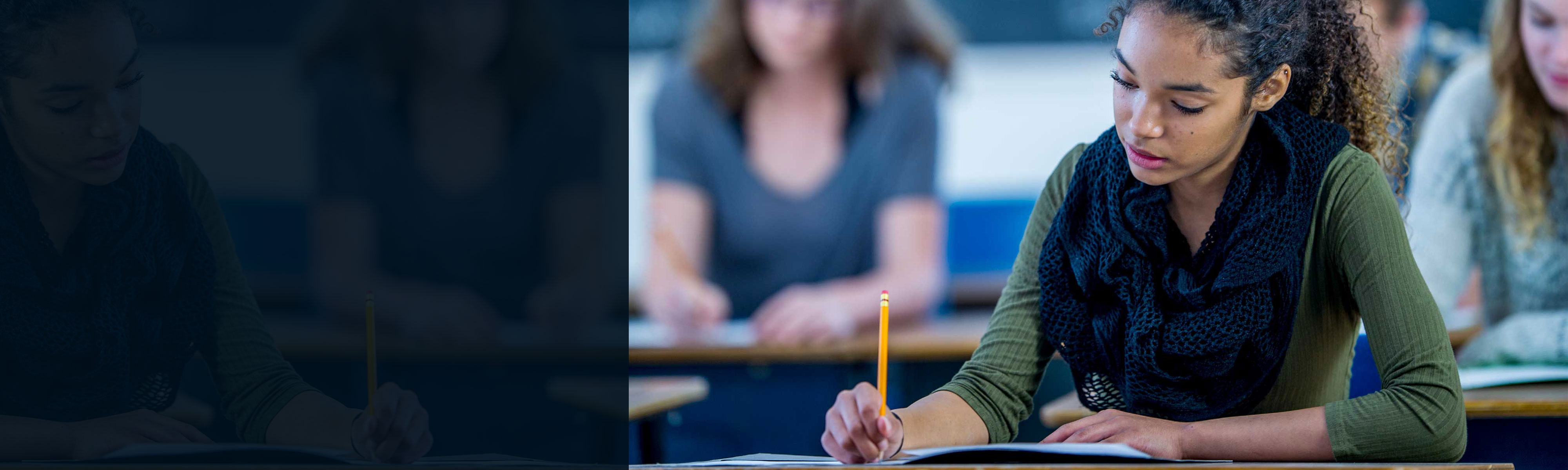 Student writing at her desk in a classroom